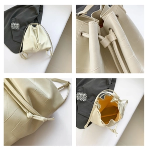 Detail view of cream bucket bag with geometric stitching and vibrant yellow lining