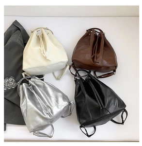 Top view of four bucket bags in cream, brown, silver, and black with drawstring detail