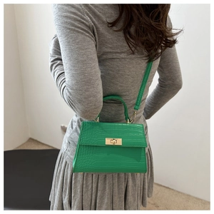 Détail du sac à main vert vif à motif crocodile et fermoir en métal doré sur modèle