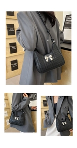 Detail of black woven shoulder bag with silver bow clasp and thin leather strap