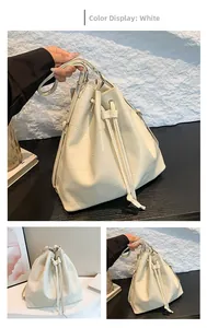 Detail of creamy white bucket bag featuring geometric patchwork and drawstring closure