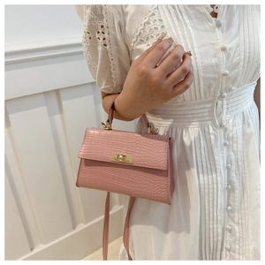 Detail of pink croc-embossed handbag with gold rectangular twist-lock and top handle