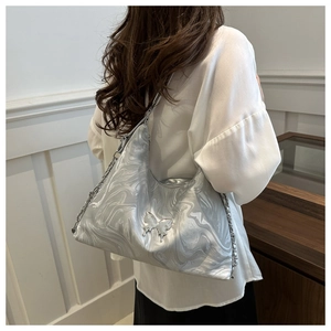 Silver metallic shoulder bag with butterfly logo and chain strap on a white shirt