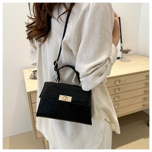 Détail du sac bandoulière vintage noir avec motif crocodile et fermoir doré chic