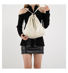 Detail of off-white bucket bag featuring unique square quilted texture and drawstring closure