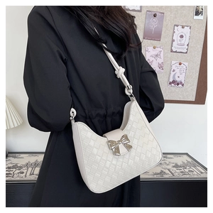 Detail of white woven hobo bag with silver bow accent and knotted shoulder strap