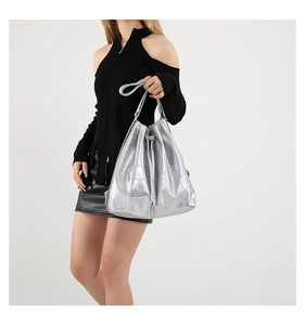 Detail view of large silver metallic bucket bag with quilted texture and drawstring closure