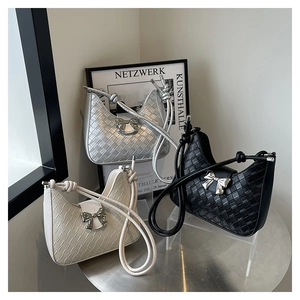 Three woven crescent bags in silver, cream and black with metallic bow details