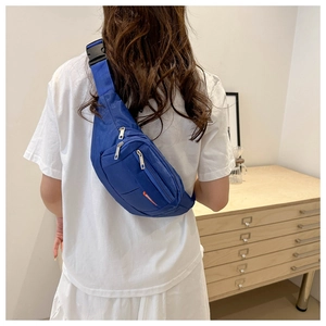 Detail view of the multi-layered blue canvas waist bag with sport label and secure buckle
