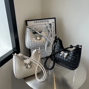 Minimalist woven hobo bag with metallic bow detail in silver, cream, and black colors