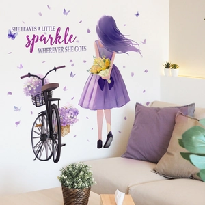 Detail view of girl on bicycle wall decal with butterflies and purple flowers