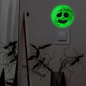 Luminous Halloween wall sticker showing a glowing green moon with a skull face on a switch