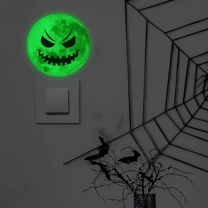 Macro detail of Halloween glowing moon wall sticker with devil face above light switch