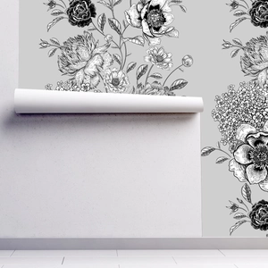 Detailopname van vintage zwart-wit bloemenbehang dat op een grijze muur wordt geplakt