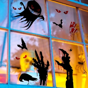 Close-up of Halloween window stickers featuring black ghosts and red blood handprints