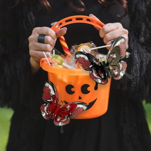 Detailed view of 3D skull rose butterfly stickers on a Halloween pumpkin bucket