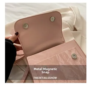 Detail showing dual magnetic closures on a pink patent leather backpack for women