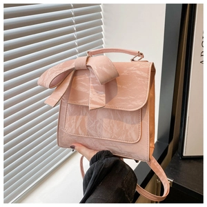 Detail of pink bow backpack with marble texture showing handle and flap closure