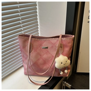 Pink quilted tote bag with cute cloud charm and metal logo tag in natural sunlight
