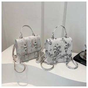 Close-up of butterfly print crossbody bags in pink and black with starry patterns