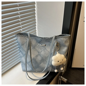 Blue denim tote bag with diamond stitching and a white cloud plush charm on a windowsill