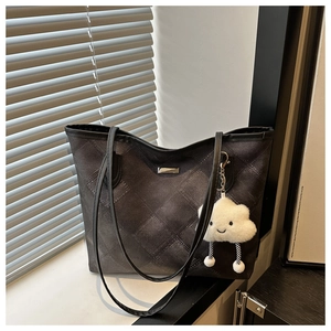 Detail of grey quilted tote bag with diamond stitching and cute plush cloud pendant