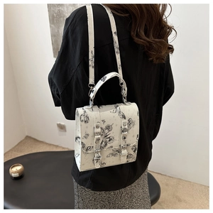 Detail of crossbody bag with butterfly print and adjustable strap on a model
