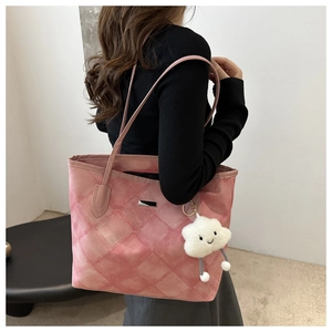 Detailed texture of pink tote bag with chic silver plaque and cute cloud plush charm
