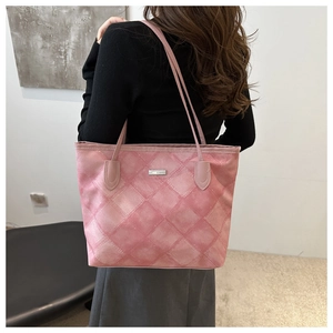 Detail of pink quilted tote bag with diamond stitching and metal logo on casual shoulder strap
