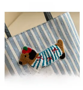 Close-up of embroidered dachshund patch on blue and white striped canvas tote bag