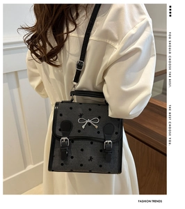 Detailed side view of vintage polka dot handbag with bow and buckle decor on model