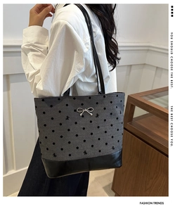Detail of grey canvas tote bag with black polka dots and silver bow accent for women