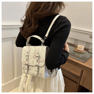 Detail of off-white mini backpack with pink butterfly print and adjustable straps