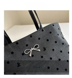 Close-up of herringbone fabric with polka dots and silver metal bow ornament detail