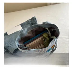 Spacious interior of blue checkered tote bag holding books, wallet, and umbrella