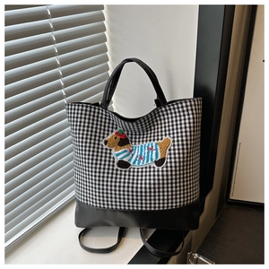 Close-up of plaid tote bag featuring a cute dachshund embroidery and leather base