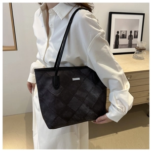 Detail der schwarzen gesteppten Shopper-Tasche mit Vintage-Textur und Logo-Schild