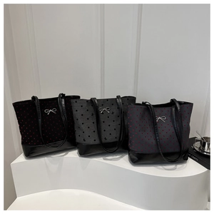 Three stylish canvas tote bags with polka dots and bow detail on a white display