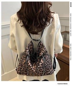 Detalle de la mochila de leopardo con forma triangular y cremalleras metálicas en modelo