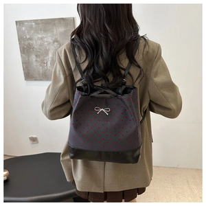 Detailed back view of grey polka dot tote with black base and silver bow detail