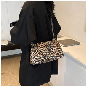 Detail of silver T-shaped metal clasp and chain strap on leopard print shoulder bag