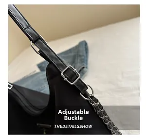 Macro detail of adjustable buckle and silver metal logo on black nylon tote bag