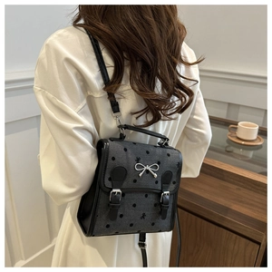 Detail des grauen gepunkteten Rucksacks mit Metallschleife und Schnallenriemen