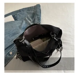 Interior view of black nylon shoulder bag showing spacious storage and purple lining