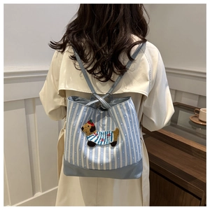 Detail view of canvas tote featuring blue white stripes and cute dog embroidery