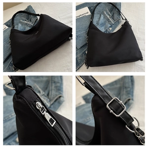 Detail view of black nylon hobo bag featuring silver triangle logo and metal hardware
