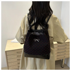 Detail of floral printed backpack featuring red heart embroidery and a silver bow detail