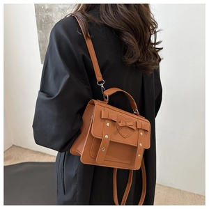 Detalle de bolso bandolera vintage caqui con relieve de corazón y lazos decorativos