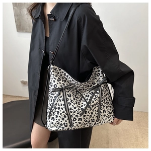 Dettaglio della borsa leopardata vintage con cerniere metalliche e fiocchi in nastro nero