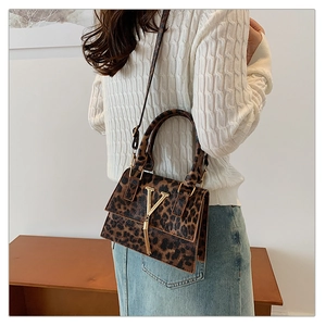 Dettaglio borsa leopardata con logo V in metallo dorato e eleganti nappe a frangia